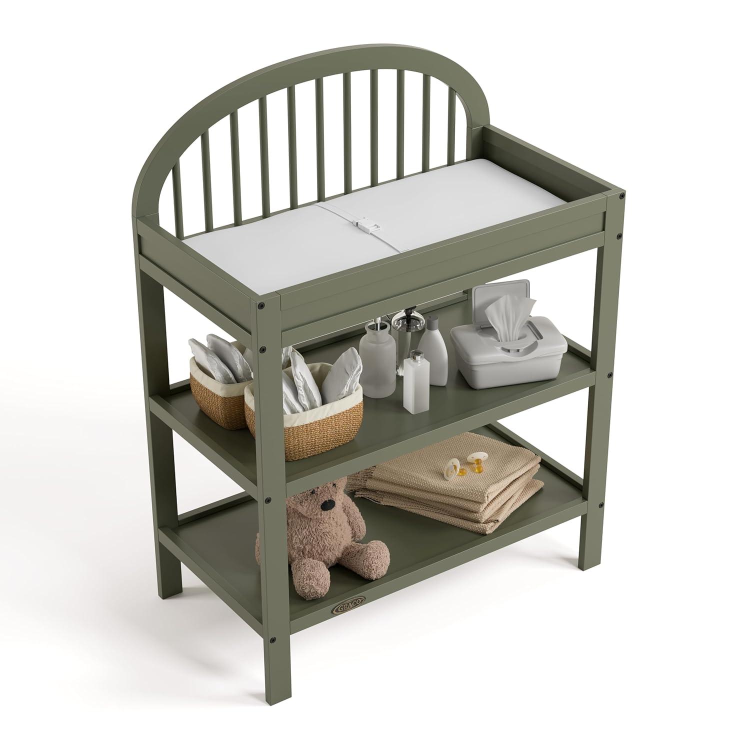 imageGraco Olivia Changing Table with WaterResistant Changing Pad Driftwood GREENGUARD Gold Certified Includes Bonus WaterResistant Changing Pad with Safety Strap 2 Open Shelves Stylish DesignOlive