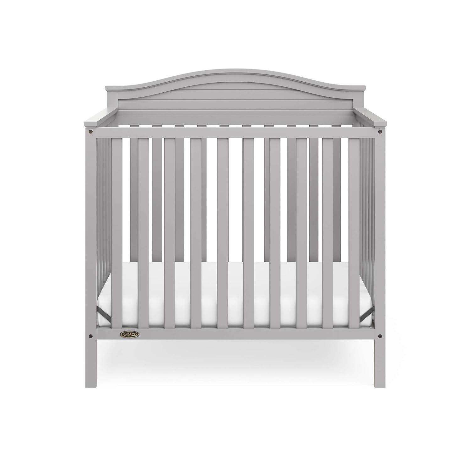 imageGraco Stella 4in1 Convertible Mini Crib with Bonus Mattress Pebble Gray Includes Bonus 275 Inch Thick Mattress with WaterResistant Cover Converts to Twin Bed Ideal Crib for Small SpacesPebble Gray